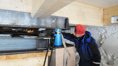 Pierre Dumont uses a blue piston to lift the station's annexes. The piston can lift up to 50 tonnes! - © International Polar Foundation, Henri Robert