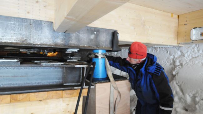 Pierre Dumont uses a blue piston to lift the station's annexes. The piston can lift up to 50 tonnes! - © International Polar Foundation, Henri Robert