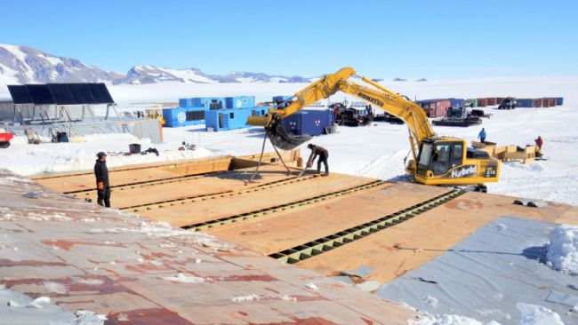 BELARE team members using a Komatsu Crane to tear down the old garage to make room for a new one - © International Polar Foundation