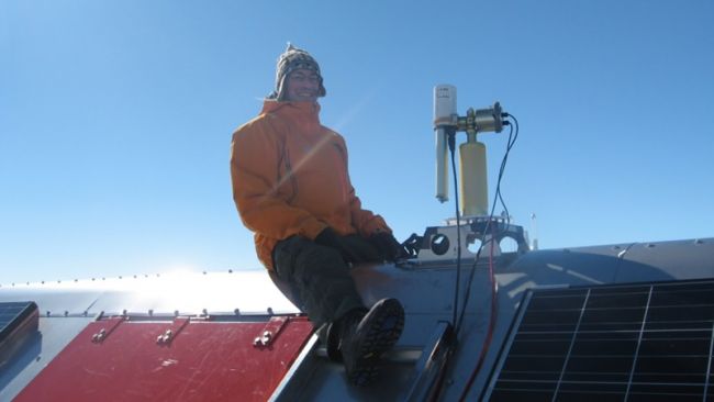 Dr. Alexander Mangold setting up an instrument on the roof of PEA - © International Polar Foundation