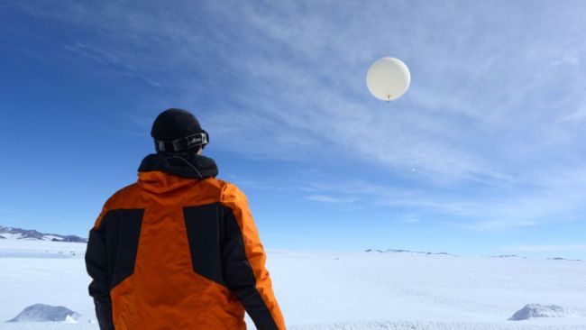Quentin Laffineur releases a meteorological balloon at Princess Elisabeth station, which will record data as it rises into the stratosphere - © International Polar Foundation / Jos van Hemelrijck