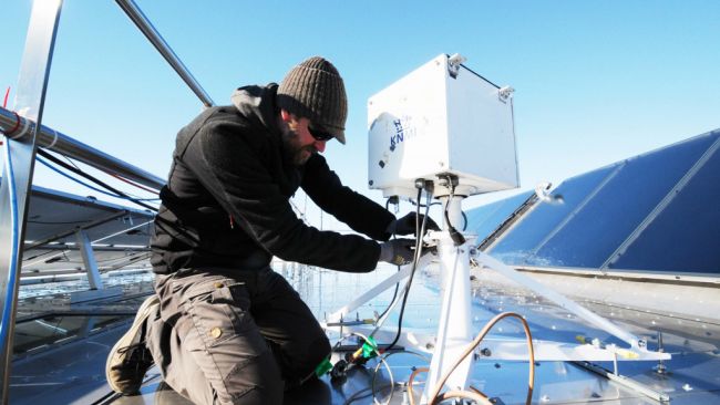 Many of the scientific instruments need to be removed from the roof of the station in order to keep them from being damaged by the rough winter conditions. Here Henri removes the Brewer Ozone-Sperctrophotometer from the Royal Meteorological Institute so it can be carefully stored until next season of data collection.
 - © International Polar Foundation