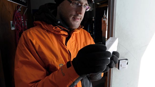 Quentin Laffineur shows us the instrument that will measure temperature, pressure and humidity as it ascends into the atmosphere. It only weighs about 100 grammes. - © International Polar Foundation / Jos Van Hemelrijck