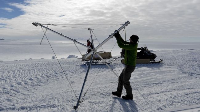 Jan Lenaerts setting up the base for the automatic weather station (AWS) he will use in the BENEMELT project. - © International Polar Foundation / Jos Van Hemelrijck