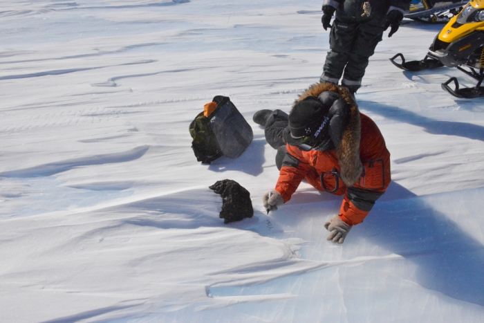 Belgo-Japanese SAMBA meteorite team members examining an 18kg meteorite found during a field trip on the Nansen Ice Field, 140km south of Princess Elisabeth Antarctica, during the BELARE 2012-2013 expedition.  - International Polar Foundation/Vinciane Debaille