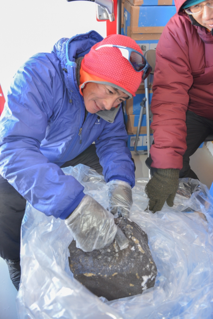 Belgo-Japanese SAMBA meteorite team member sealing an 18kg meteorite meteorite in plastic to prevent contamination, during a field trip on the Nansen Ice Field, 140km south of Princess Elisabeth Antarctica, during the BELARE 2012-2013 expedition.  - International Polar Foundation