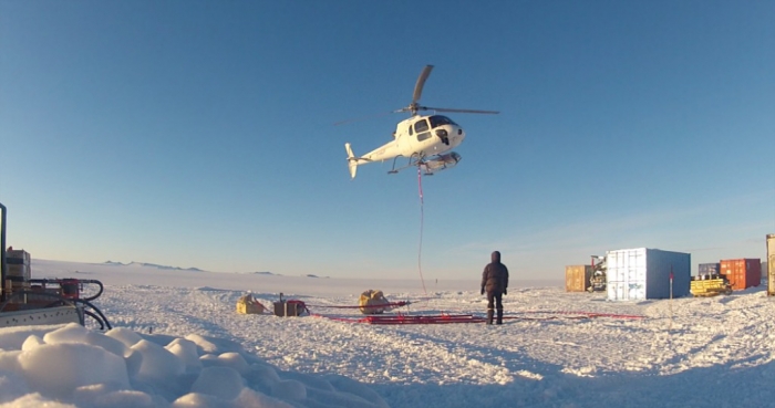 Lifting up the repeater antenna to be installed on top of Romnoes Nunatak, on the way to the coast. - International Polar Foundation