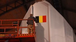 Bernard Pollet, Princess Elisabeth's future plumber in Antarctica, carefully places the Belgian flag upon the station. - International Polar Foundation