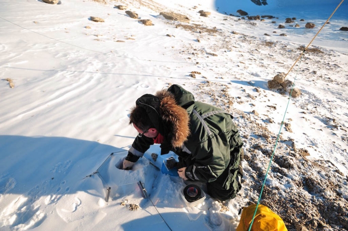 Elie collecting the data logger from one of the open top chambers and putting a new one in place - International Polar Foundation