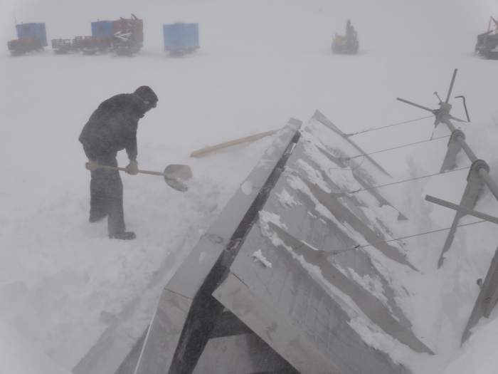 Paul has to keep the snow melter filled, even when the wind blows - International Polar Foundation